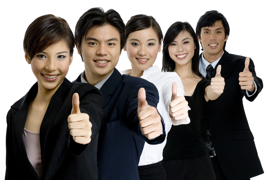 a young successful asian business team gives the thumbs up on white background