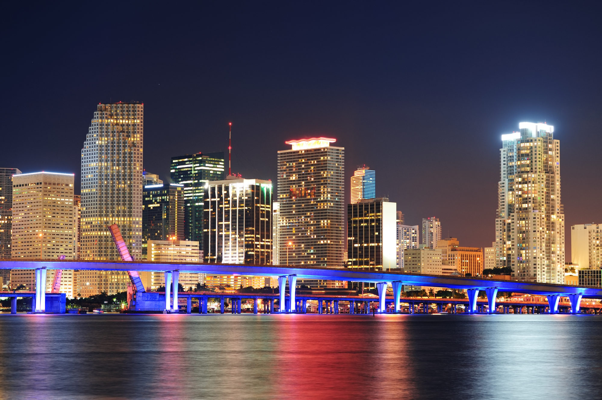 Miami City Skyline Closeup At Dusk With Urban Skyscrapers And Br Miami city skyline closeup at dusk with urban skyscrapers and bridge over sea with reflection